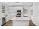 Bright kitchen with white cabinets, stainless steel appliances, island and updated lighting at 2681 Lakeside Sw Dr, Conyers, GA 30094