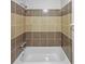 A neutral-tiled bathtub and shower with chrome fixtures at 3924 Chimney Ridge Ct, Ellenwood, GA 30294