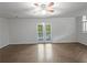 Open living room featuring a ceiling fan, hardwood floors, and a view to the patio at 3924 Chimney Ridge Ct, Ellenwood, GA 30294