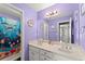Bright bathroom showcasing a double sink vanity with purple walls and fish-themed shower curtain in view at 9048 River Bend Ct, Villa Rica, GA 30180