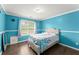 Bright bedroom features blue walls, white trim, and a plush bed, with hardwood floors at 9048 River Bend Ct, Villa Rica, GA 30180