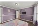 Comfortable bedroom featuring hardwood floors, soft lavender walls, and plenty of sunlight at 9048 River Bend Ct, Villa Rica, GA 30180
