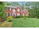 Stately brick home with a gabled roof and well-kept front yard with appealing landscaping at 9048 River Bend Ct, Villa Rica, GA 30180