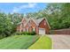Attractive brick home with a side-entry garage and lush, green surroundings on a sunny day at 9048 River Bend Ct, Villa Rica, GA 30180