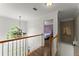 Upstairs hallway with chandelier and view of bedroom with purple headboard at 9048 River Bend Ct, Villa Rica, GA 30180