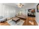 Bright living room featuring hardwood floors, neutral-toned sofa, and an open view to the kitchen at 9048 River Bend Ct, Villa Rica, GA 30180