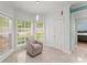 Bright sun room with tile floors, chair, and views of the backyard through windows at 9048 River Bend Ct, Villa Rica, GA 30180