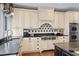 Elegant kitchen with white cabinetry, stainless steel appliances, granite countertops, and designer backsplash at 162 Daltree Ct, Marietta, GA 30068