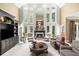 Bright living room with soaring ceilings, large windows and fireplace, and custom-built ins with a display case at 162 Daltree Ct, Marietta, GA 30068
