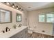 Bathroom with dual sinks, framed mirrors, and natural light from the window at 2020 Commonwealth Pl, Cumming, GA 30041