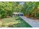 Charming single Gathering home featuring a long driveway and inviting front porch, all surrounded by lush greenery at 2020 Commonwealth Pl, Cumming, GA 30041