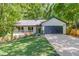 Charming single-story home features a well-kept lawn, covered porch, and two-car garage nestled among mature trees at 2020 Commonwealth Pl, Cumming, GA 30041