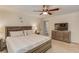 A spacious primary bedroom featuring a wood bed frame, ceiling fan, and an ensuite bathroom at 2020 Commonwealth Pl, Cumming, GA 30041