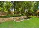 Beautiful backyard featuring a stone retaining wall, small koi pond, and healthy green grass at 2595 Winthrope Way, Lawrenceville, GA 30044