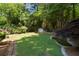 Private backyard showcasing a stone retaining wall, koi pond, and vibrant green lawn at 2595 Winthrope Way, Lawrenceville, GA 30044