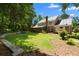 Expansive backyard with a stone retaining wall, healthy lawn, and a sunroom off the rear of the home at 2595 Winthrope Way, Lawrenceville, GA 30044