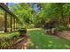 Scenic backyard with lush greenery, mature trees, and a tranquil water feature at 2595 Winthrope Way, Lawrenceville, GA 30044