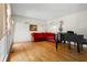 Elegant living room featuring hardwood floors, a grand piano, and a comfortable red corner sofa at 2595 Winthrope Way, Lawrenceville, GA 30044