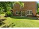 Brick home with a walk-out patio and green lawn, creating an inviting outdoor space at 2595 Winthrope Way, Lawrenceville, GA 30044