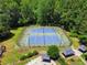 Aerial view of blue tennis courts surrounded by a tall fence, trees, and nearby recreation area at 2595 Winthrope Way, Lawrenceville, GA 30044