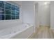 Relaxing bathroom showcases a jetted tub and a large window with a wooded view at 402 Wood Chase Ln, Canton, GA 30114