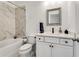 Modern bathroom featuring marble tile surround on tub/shower and decorative mirror and vanity at 6635 Beacon Dr, Atlanta, GA 30328