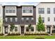 Attractive townhome exterior with a mix of white brick and dark wood, accented by young trees at 6635 Beacon Dr, Atlanta, GA 30328