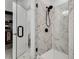 Elegant glass enclosed shower featuring modern fixtures and marble tiling, adjacent to walk-in closet at 6635 Beacon Dr, Atlanta, GA 30328