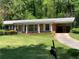 Charming brick home featuring a covered carport, front porch, and well-maintained lawn at 2703 Arrowood Dr, East Point, GA 30344
