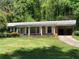 Charming brick home featuring a covered carport, front porch, and well-maintained lawn at 2703 Arrowood Dr, East Point, GA 30344