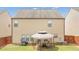A view of the home's backyard with green grass, a fence and patio set with table and chairs at 556 Emporia Loop, Mcdonough, GA 30253