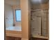 Bathroom featuring a walk-in shower, soaking tub, and a large window for natural light at 556 Emporia Loop, Mcdonough, GA 30253