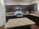 Kitchen features stainless steel appliances, granite counters, an island, and dark wood cabinets at 556 Emporia Loop, Mcdonough, GA 30253