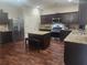 Spacious kitchen boasts stainless steel appliances, granite counters, an island, and stylish dark wood cabinets at 556 Emporia Loop, Mcdonough, GA 30253