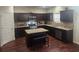 Well-lit kitchen featuring dark wood cabinets, stainless steel appliances, and granite countertops at 556 Emporia Loop, Mcdonough, GA 30253