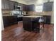 Well-lit kitchen with dark wood cabinets, stainless steel appliances, granite countertops, and central island at 556 Emporia Loop, Mcdonough, GA 30253