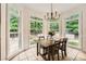 The bright breakfast nook is surrounded by windows overlooking a green backyard at 5940 Plantation Dr, Roswell, GA 30075