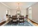 Formal dining room with hardwood floors, chair rail molding, and designer light fixture at 5940 Plantation Dr, Roswell, GA 30075