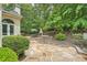 Outdoor stone patio with fireplace and dining area nestled in a private, wooded backyard at 5940 Plantation Dr, Roswell, GA 30075
