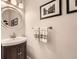 Charming powder room with framed art, neutral paint, and a round mirror at 5940 Plantation Dr, Roswell, GA 30075