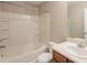 Bathroom featuring a white vanity, commode, and a shower-tub combo with white tile surround at 1851 Grove Way, Hampton, GA 30228