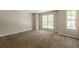 Spacious bedroom with neutral walls, carpet flooring, and two large windows providing ample natural light at 1851 Grove Way, Hampton, GA 30228