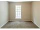 Bedroom with neutral walls, plush carpeting, and a window for natural light at 1851 Grove Way, Hampton, GA 30228