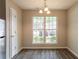 Bright dining area with a modern chandelier, laminate wood flooring, and a large window at 1851 Grove Way, Hampton, GA 30228