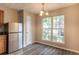 Bright dining area with a stainless steel refrigerator, modern chandelier, and a large window at 1851 Grove Way, Hampton, GA 30228