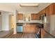 Well-lit kitchen with wood cabinetry, stainless steel appliances, and a pass-through to the dining area at 1851 Grove Way, Hampton, GA 30228