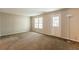Cozy living room with neutral walls, carpet flooring, and a back door leading to outdoor space at 1851 Grove Way, Hampton, GA 30228
