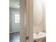 Half bath features a modern round mirror, a white sink, and views to the front door at 1851 Grove Way, Hampton, GA 30228