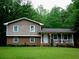 Charming two-story home featuring a brick base and siding on the upper level, set amongst mature trees at 2592 King Louis Ne Rd, Conyers, GA 30012