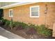 Exterior elevation featuring decorative shrubs and a brick facade at 2592 King Louis Ne Rd, Conyers, GA 30012